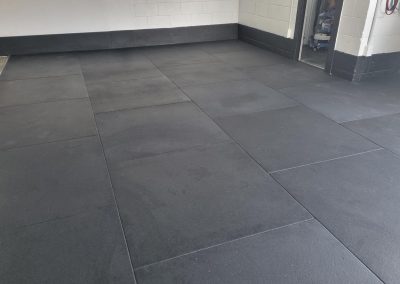 Example of how black rubber gym mats look installed.